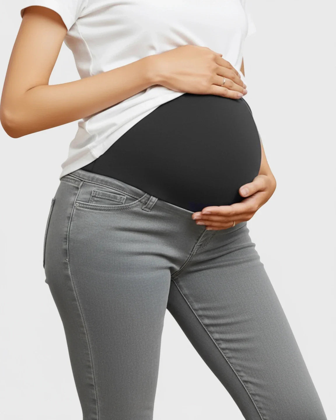 Pregnant woman wearing gray skinny maternity jeans with a black high-waist stretch panel.