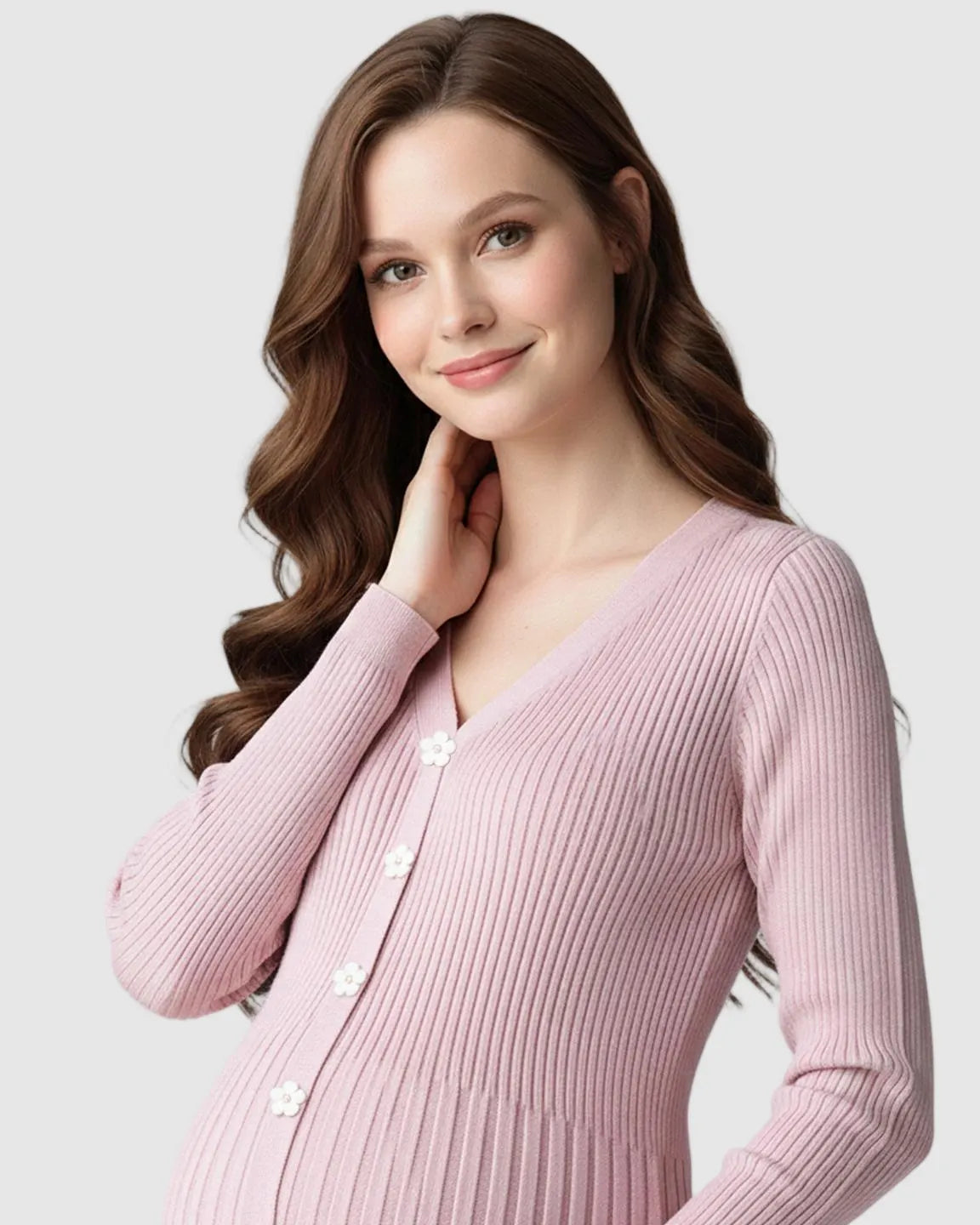 Smiling pregnant woman in a pink ribbed knit maternity midi dress with a V-neck and white flower buttons.