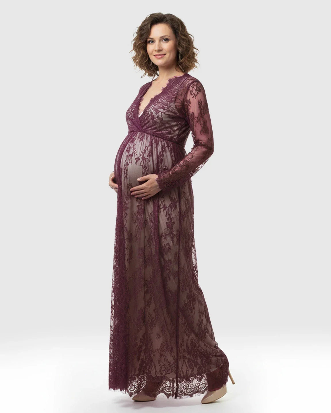 Maternity maxi dress in sheer floral plum lace with an empire waist and V-neck, worn by a pregnant woman.