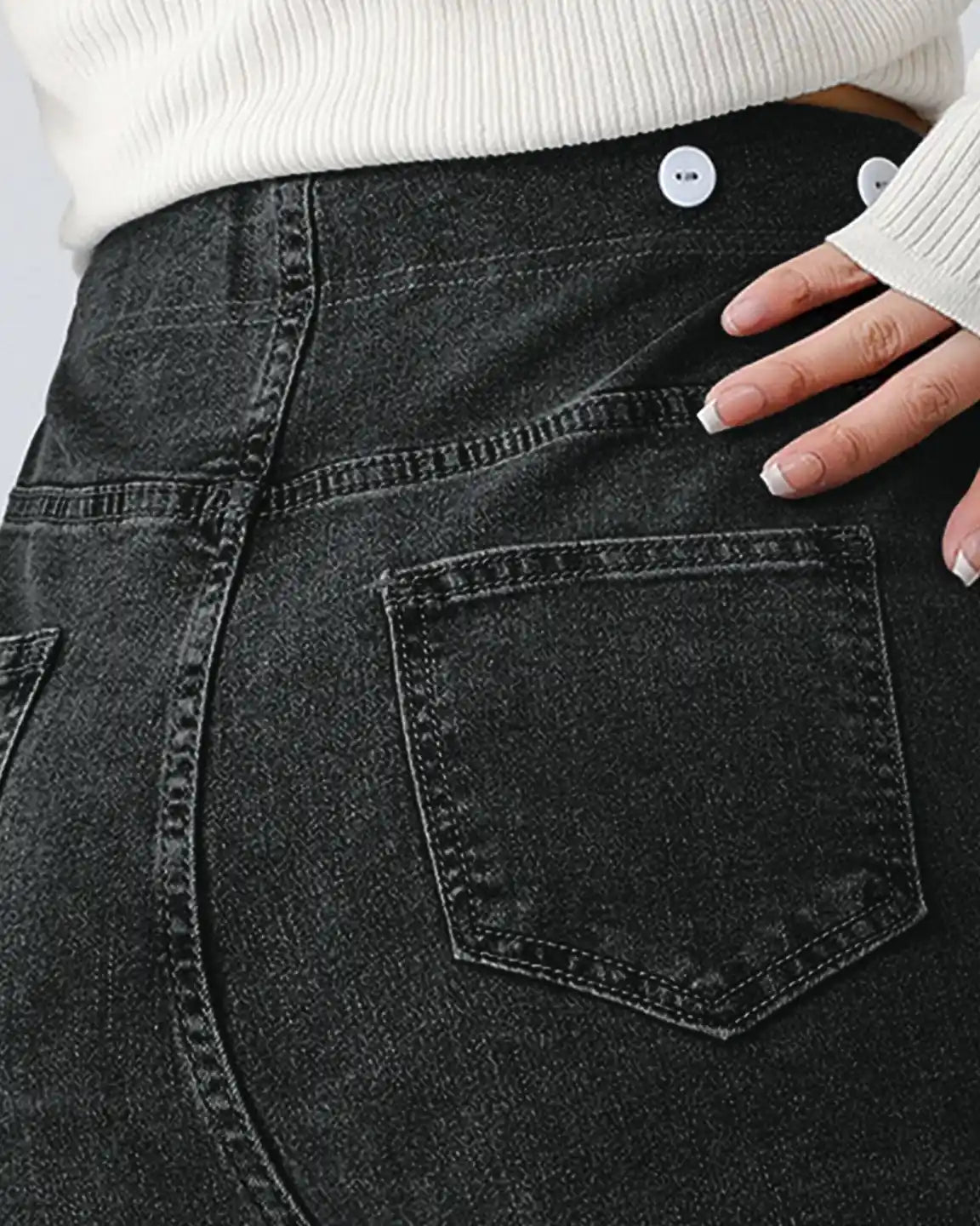Close-up of a pregnant woman wearing dark wash stretch denim straight-leg maternity jeans with white buttons.