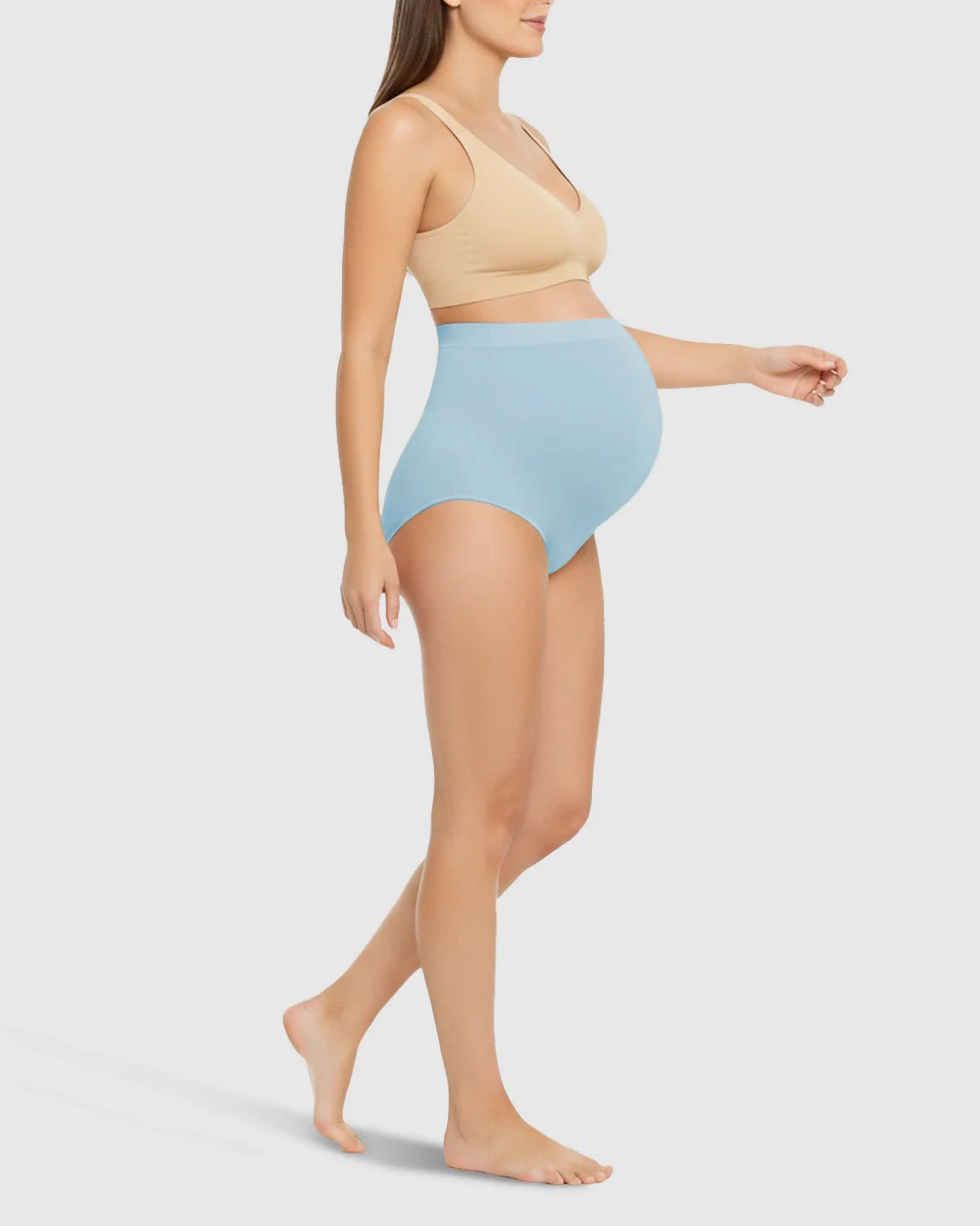 Maternity model wearing light blue high-waist seamless belly-support underwear with a nude bra.