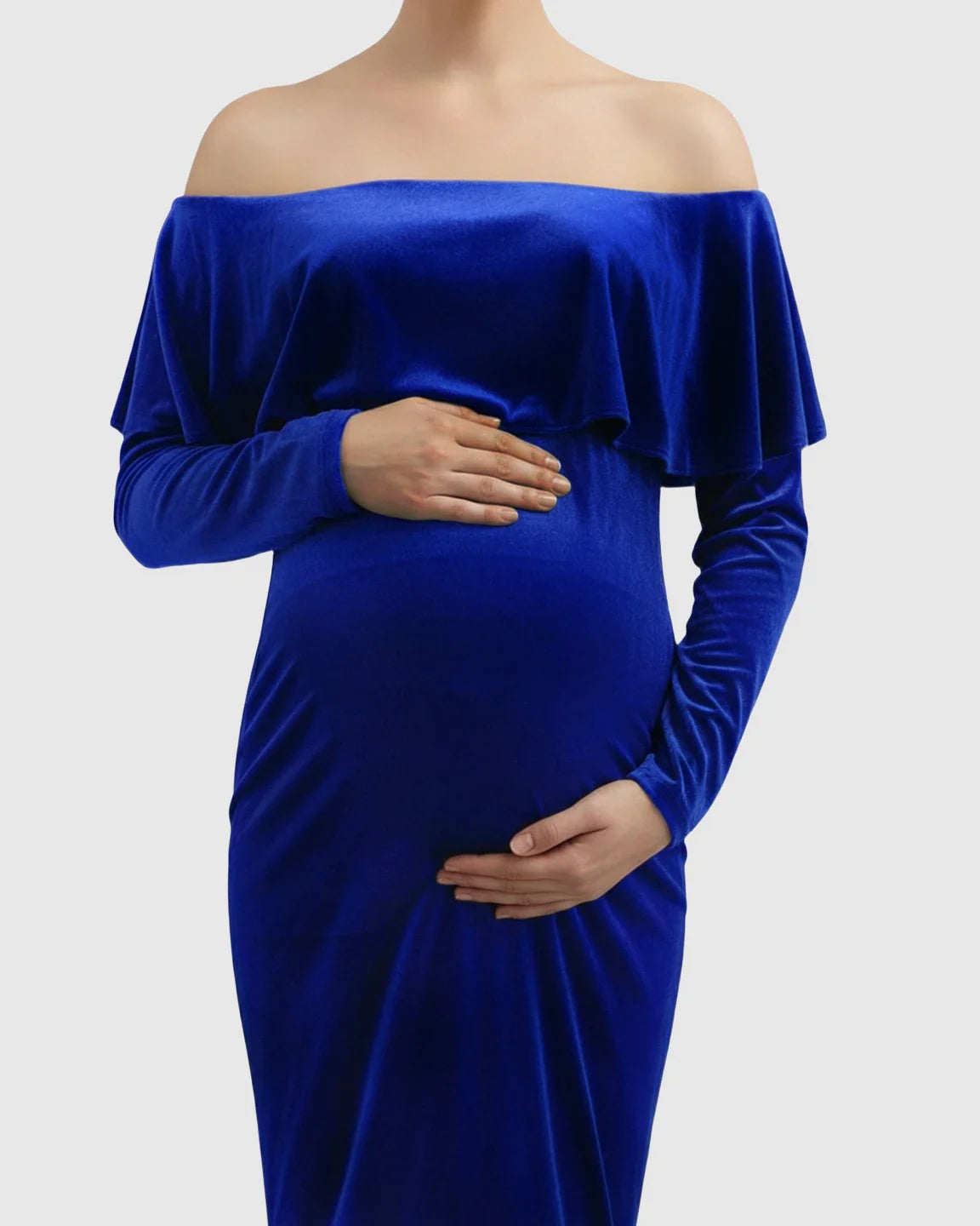 Royal blue velvet off-shoulder maternity gown with long sleeves and a flowing train, highlighting a pregnant belly.