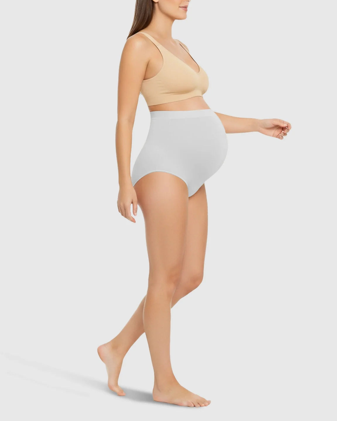 Pregnant woman in light grey high-waist seamless belly-support maternity underwear and a nude bra.
