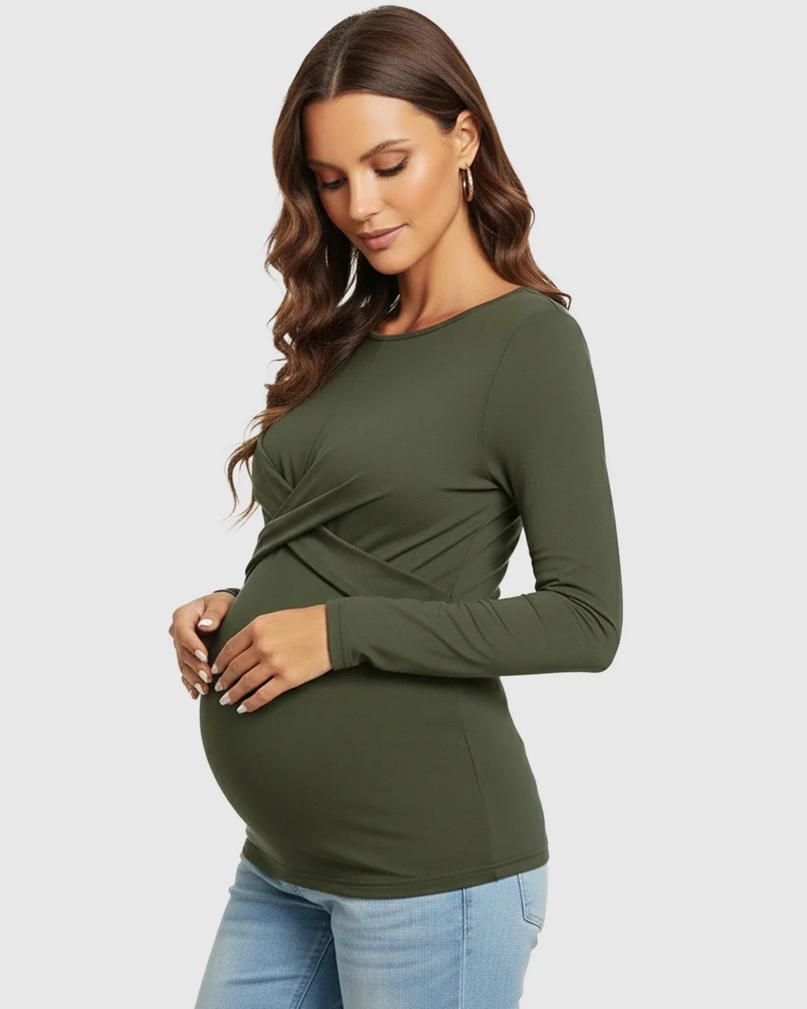 Maternity model in an olive green cross-pleat fitted long sleeve top, highlighting her bump.