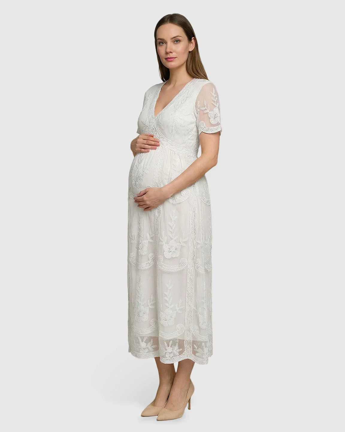 Pregnant woman in a white lace maternity midi dress with V-neck, three-quarter sleeves, and swing skirt.