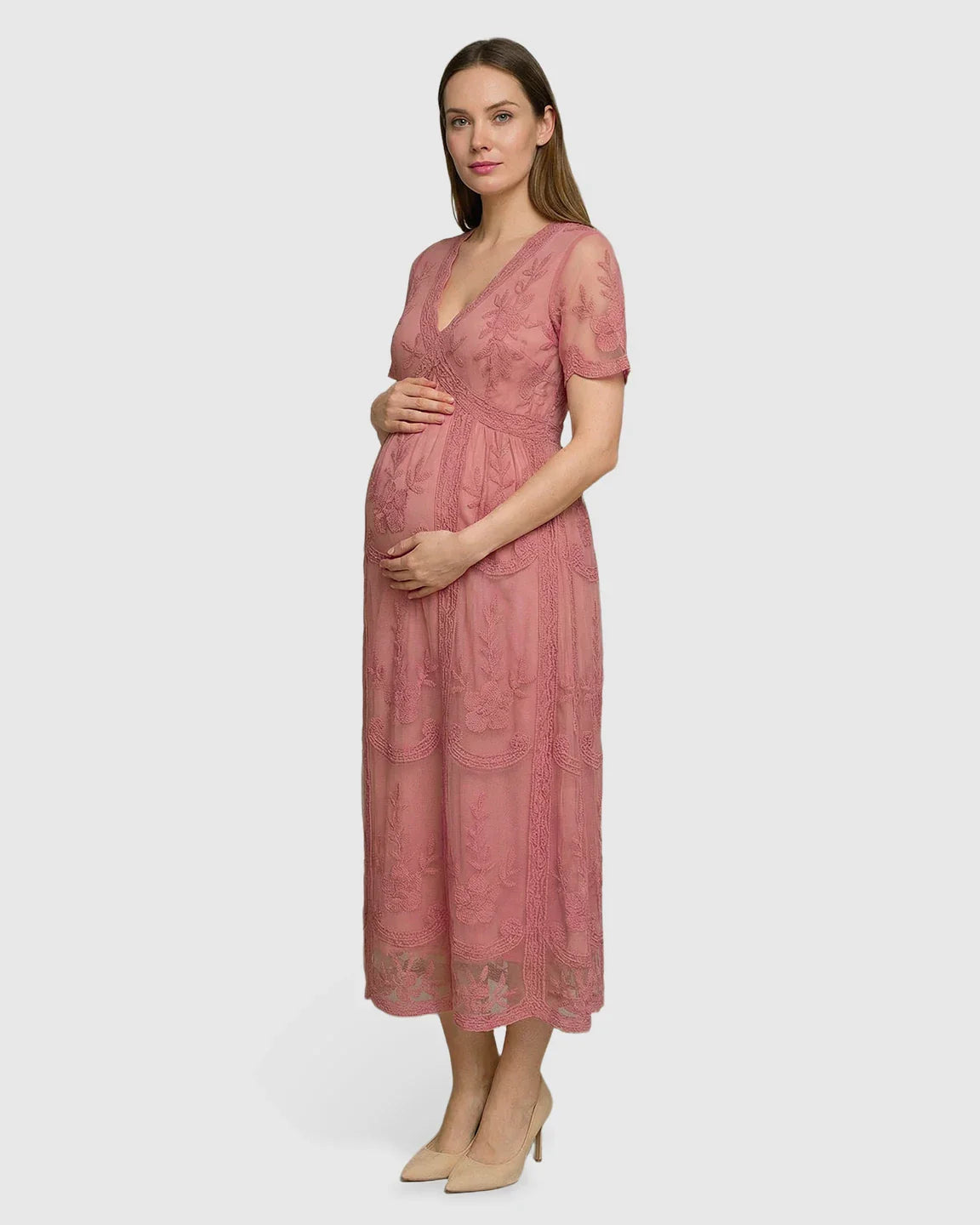 Maternity midi dress in pink lace with V-neck, three-quarter sleeves, and swing skirt, worn by a pregnant woman.