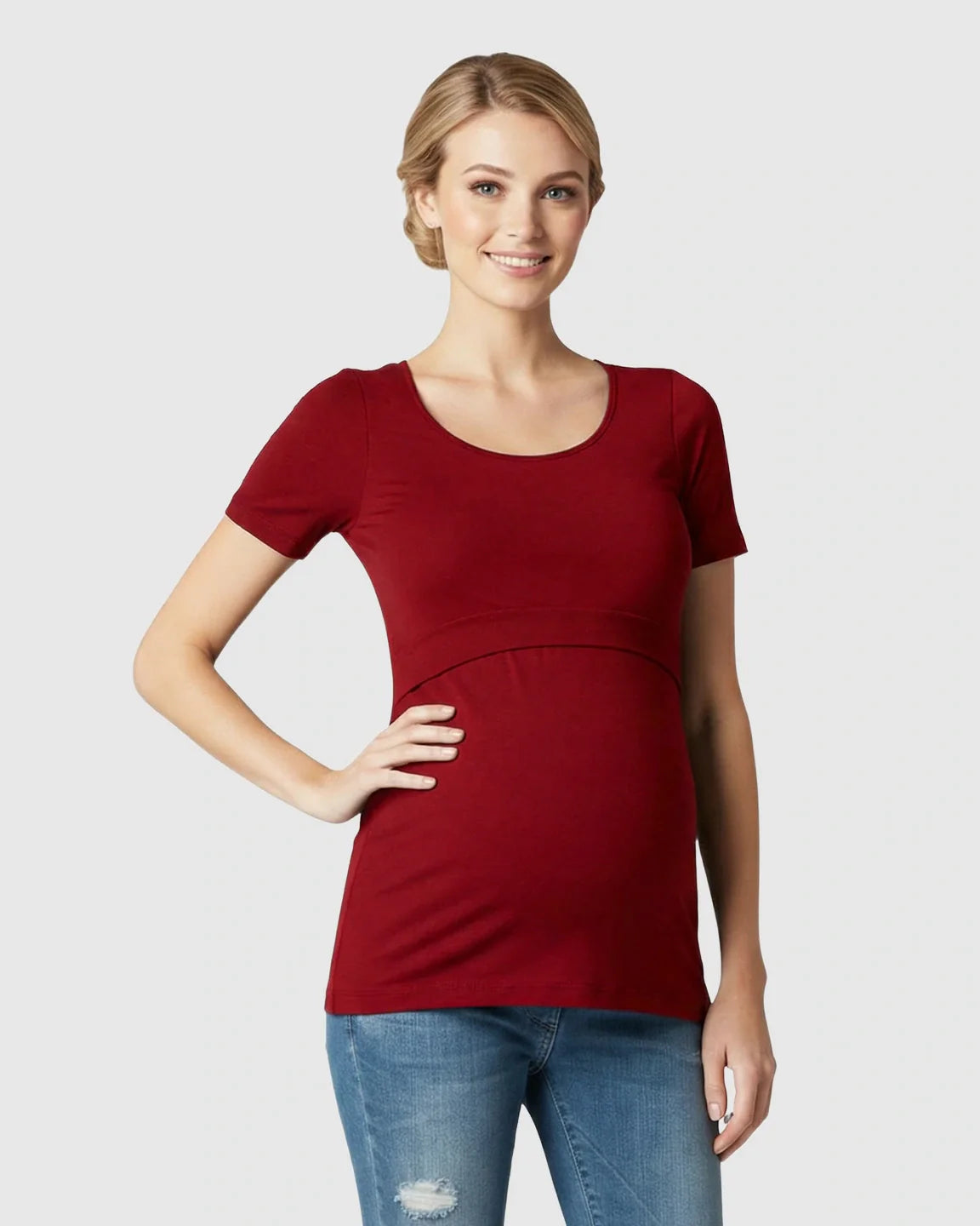 Smiling woman in a red stretch-fit v-neck nursing t-shirt with easy access, paired with jeans.