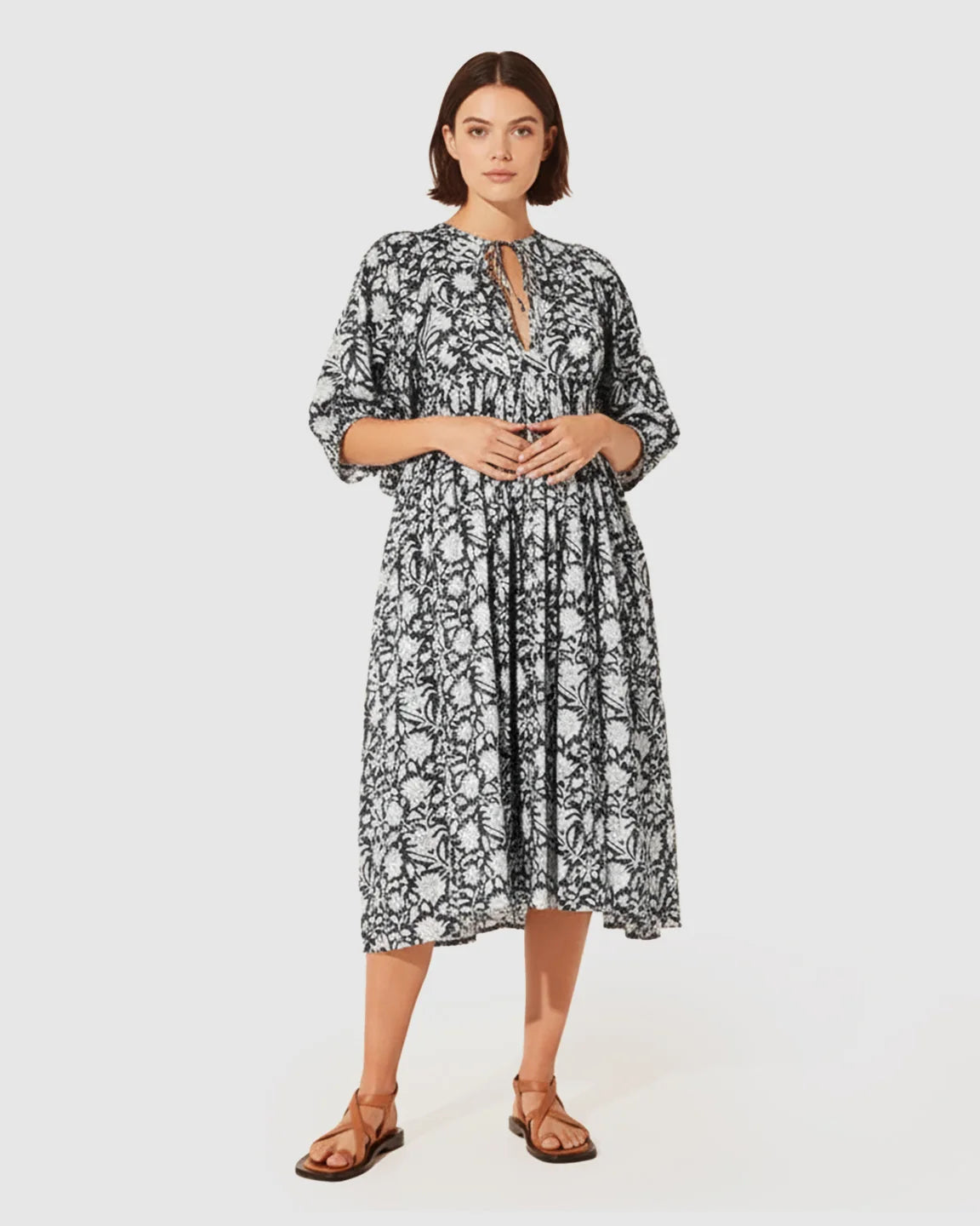 Black and white floral maternity midi dress with gathered shoulders, puff sleeves, and knot detail.