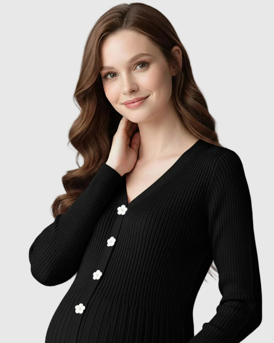 Pregnant woman in a black ribbed knit maternity midi dress with long sleeves, V-neck, and white floral buttons.