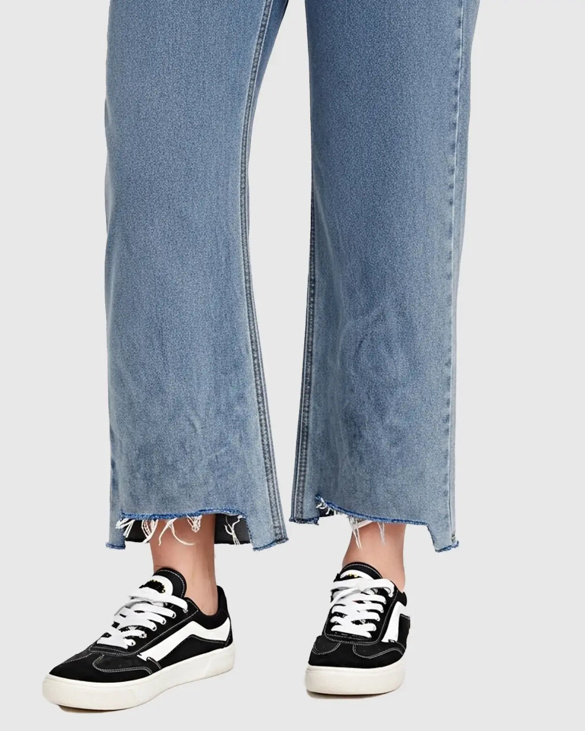 Light wash wide-leg maternity jeans with a raw hem, worn with black and white sneakers.