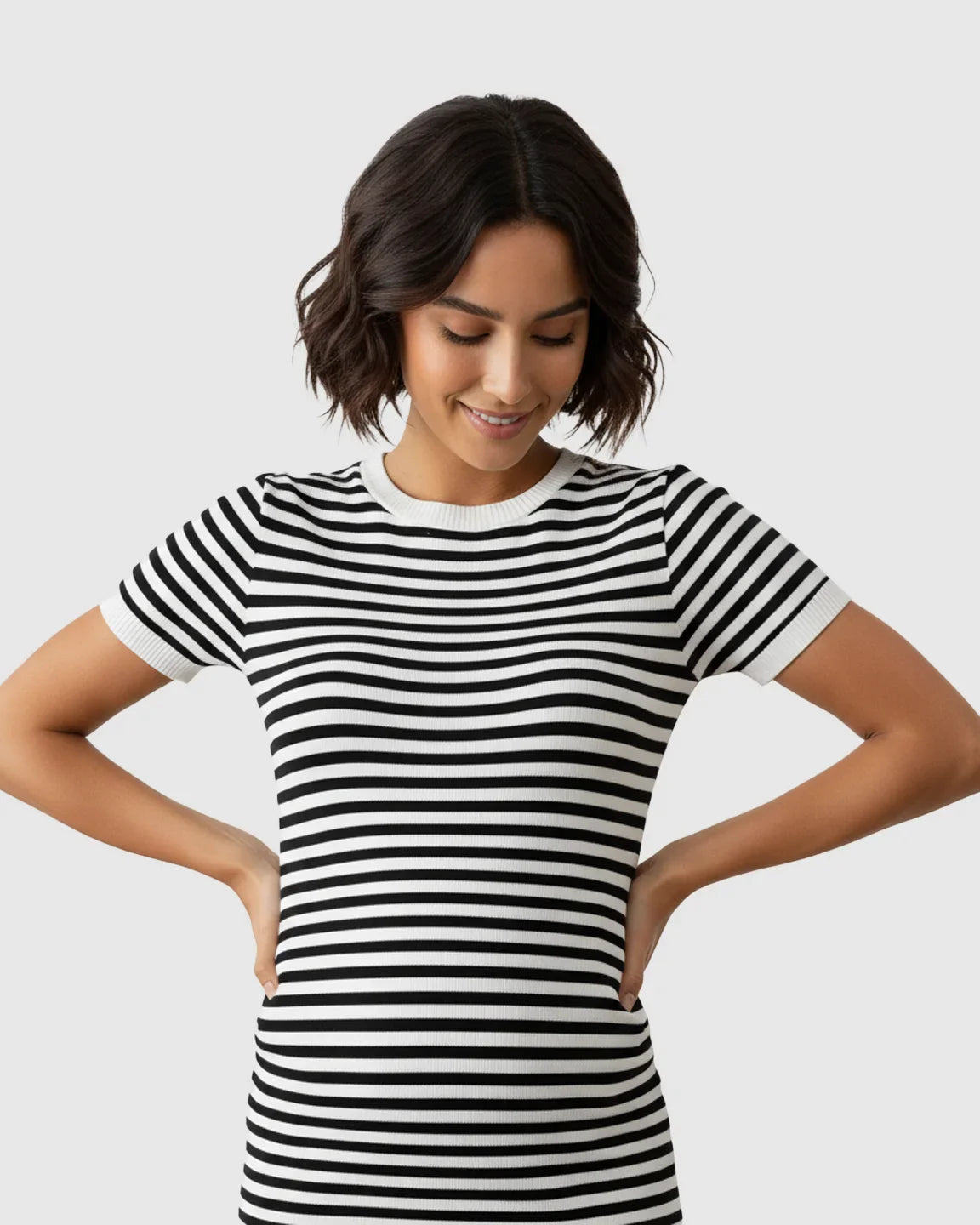 Smiling pregnant woman in a black and white striped short-sleeve maternity column dress.