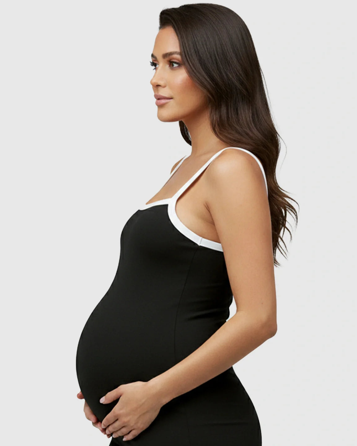 Maternity model in black sleeveless jumpsuit with white trim, designed for comfort.