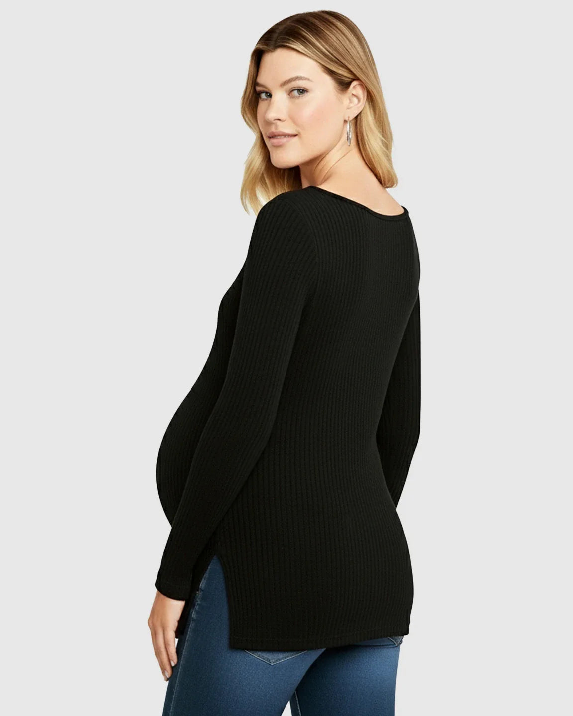 Blonde pregnant woman wearing a black ribbed V-neck long sleeve maternity top with side slits and jeans.