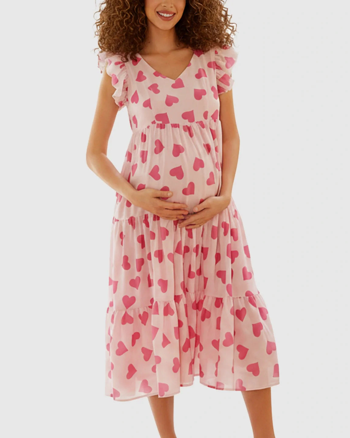 Maternity midi dress in light pink chiffon with dark pink heart print, tiered skirt, and ruffle sleeves.