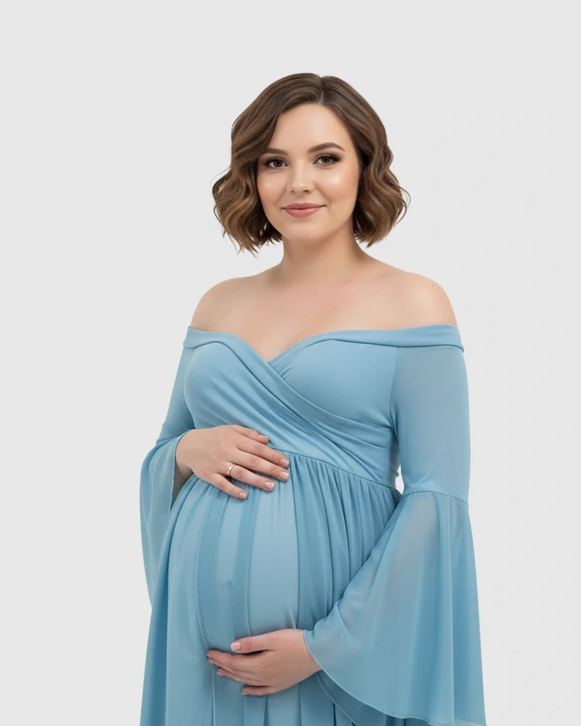 Pregnant woman in a blue off-shoulder chiffon maternity gown with bell sleeves, cradling her bump.