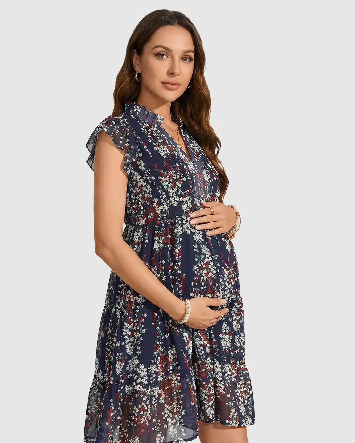 Pregnant woman in a navy chiffon floral print maternity dress with flutter sleeves and an A-line design.