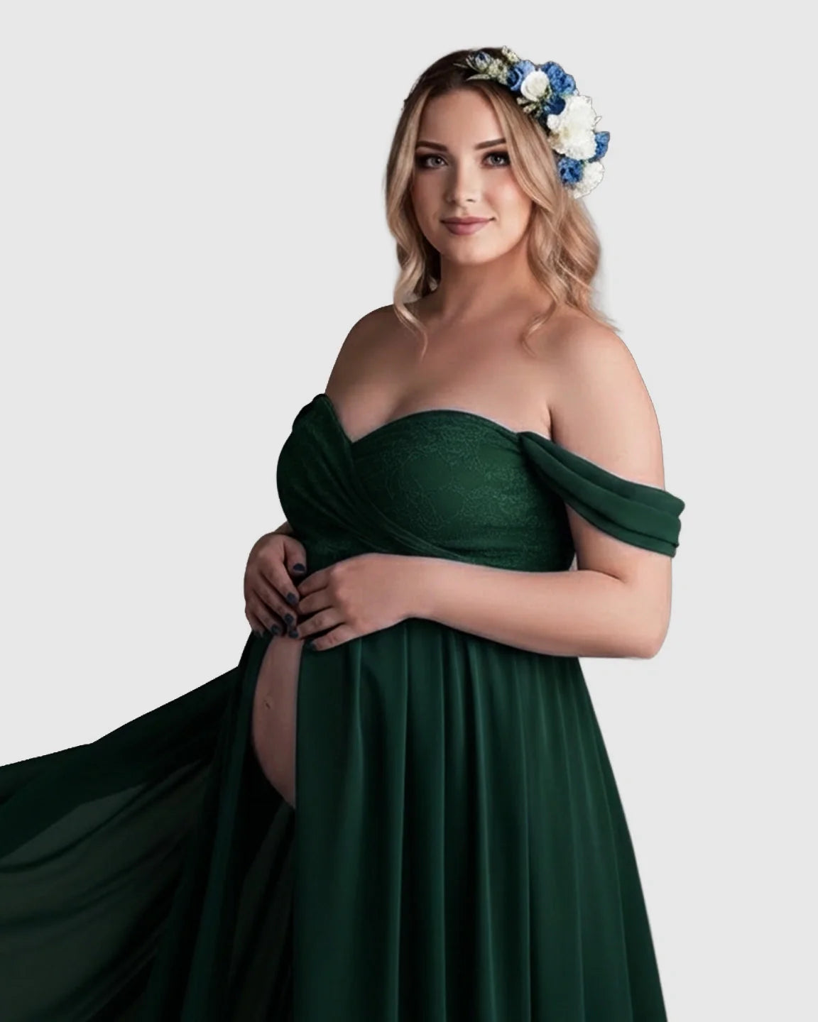 Pregnant woman in an off-shoulder, dark green chiffon maternity gown with a floral crown.
