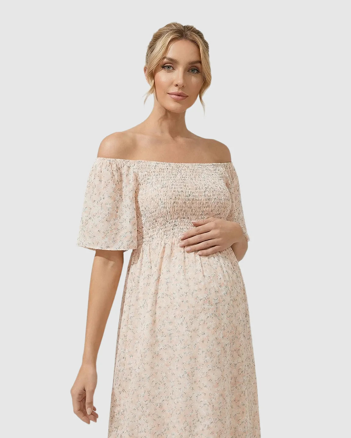 Maternity midi dress in light pink with smocked off-shoulder top, flutter sleeves, and floral print.
