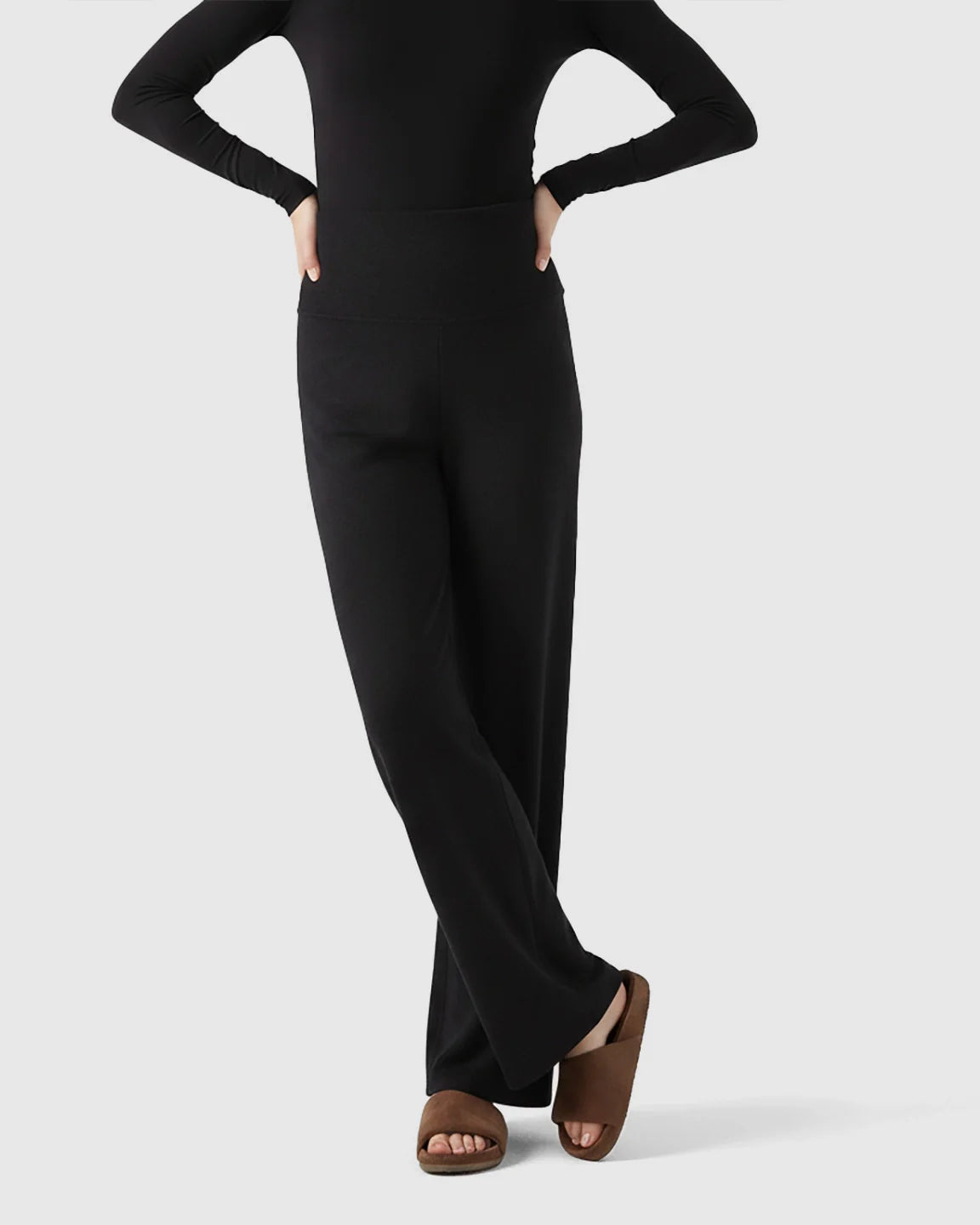 Black fleece-lined maternity pants with over-belly waistband and wide-leg silhouette.