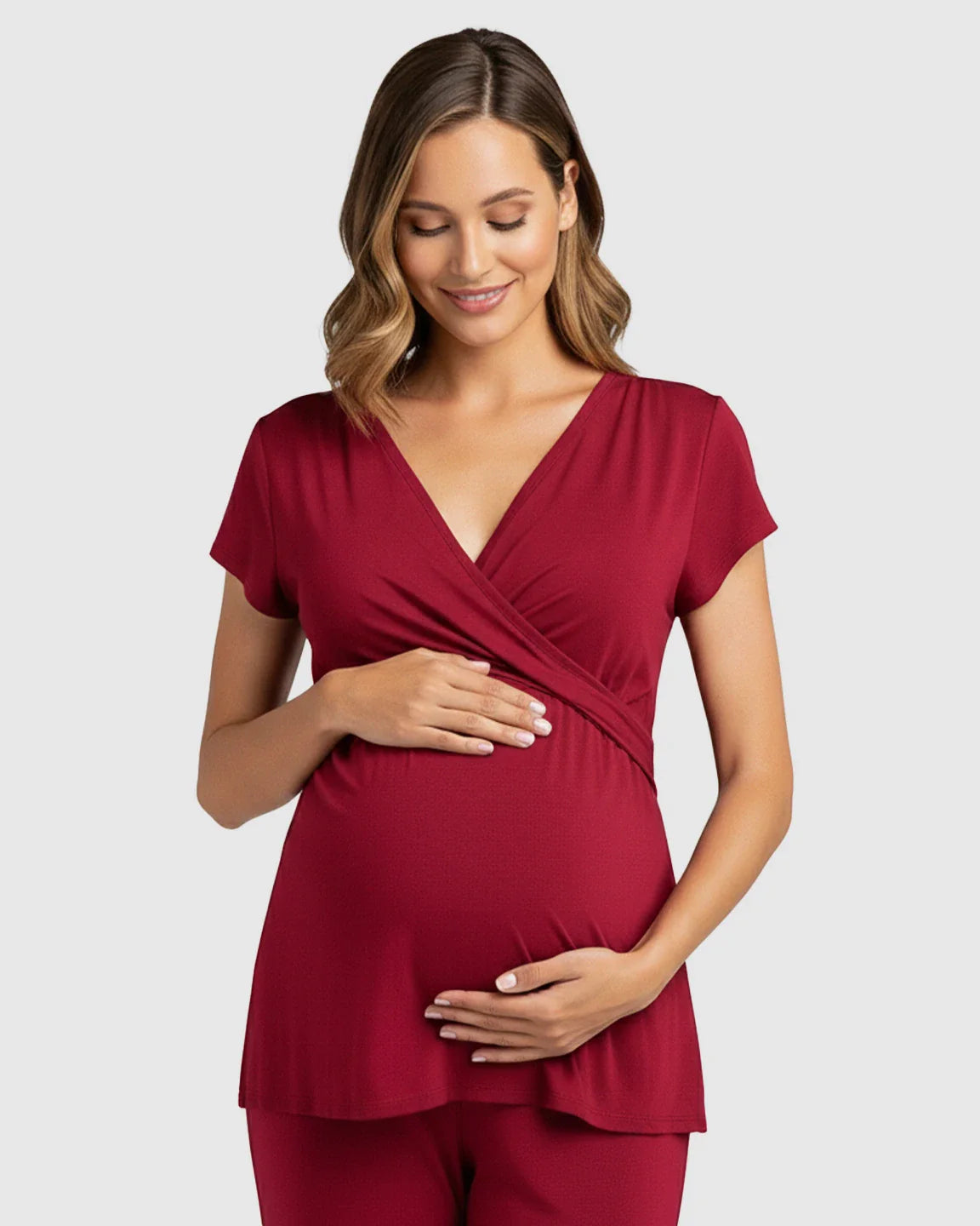 Smiling pregnant woman in a soft, red wrap V-neck short-sleeve maternity & nursing sleepwear top.