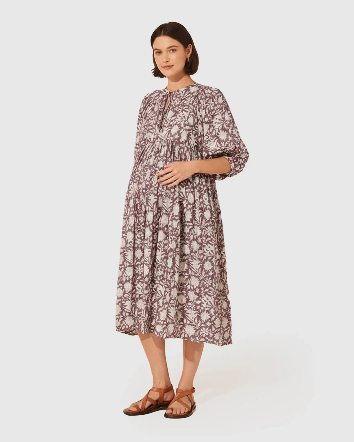 Pregnant woman in a loose-fit, gathered shoulder floral print maternity midi dress with puff sleeves.