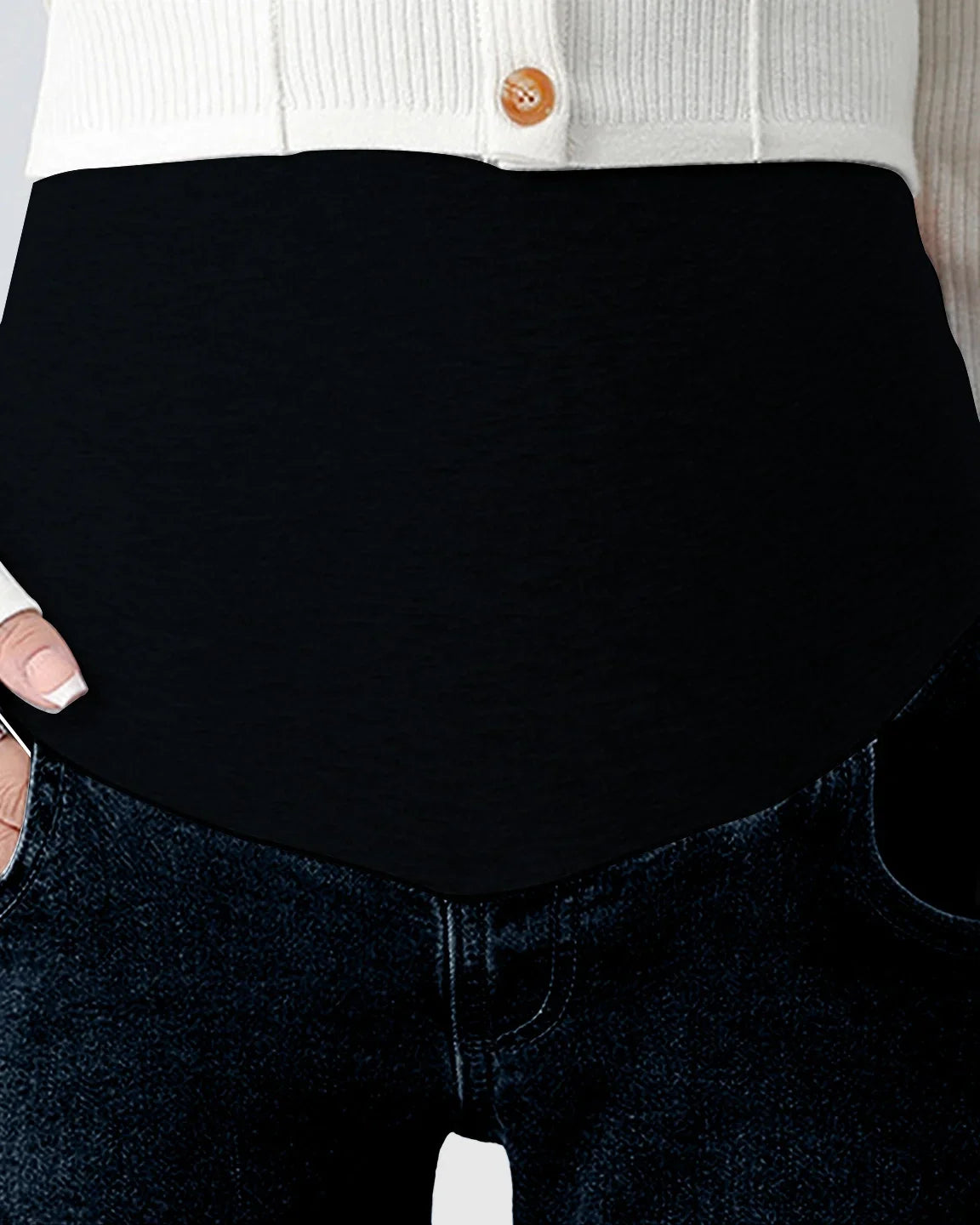 Dark wash straight-leg maternity jeans with a black over-the-belly stretch panel, paired with a white cardigan.