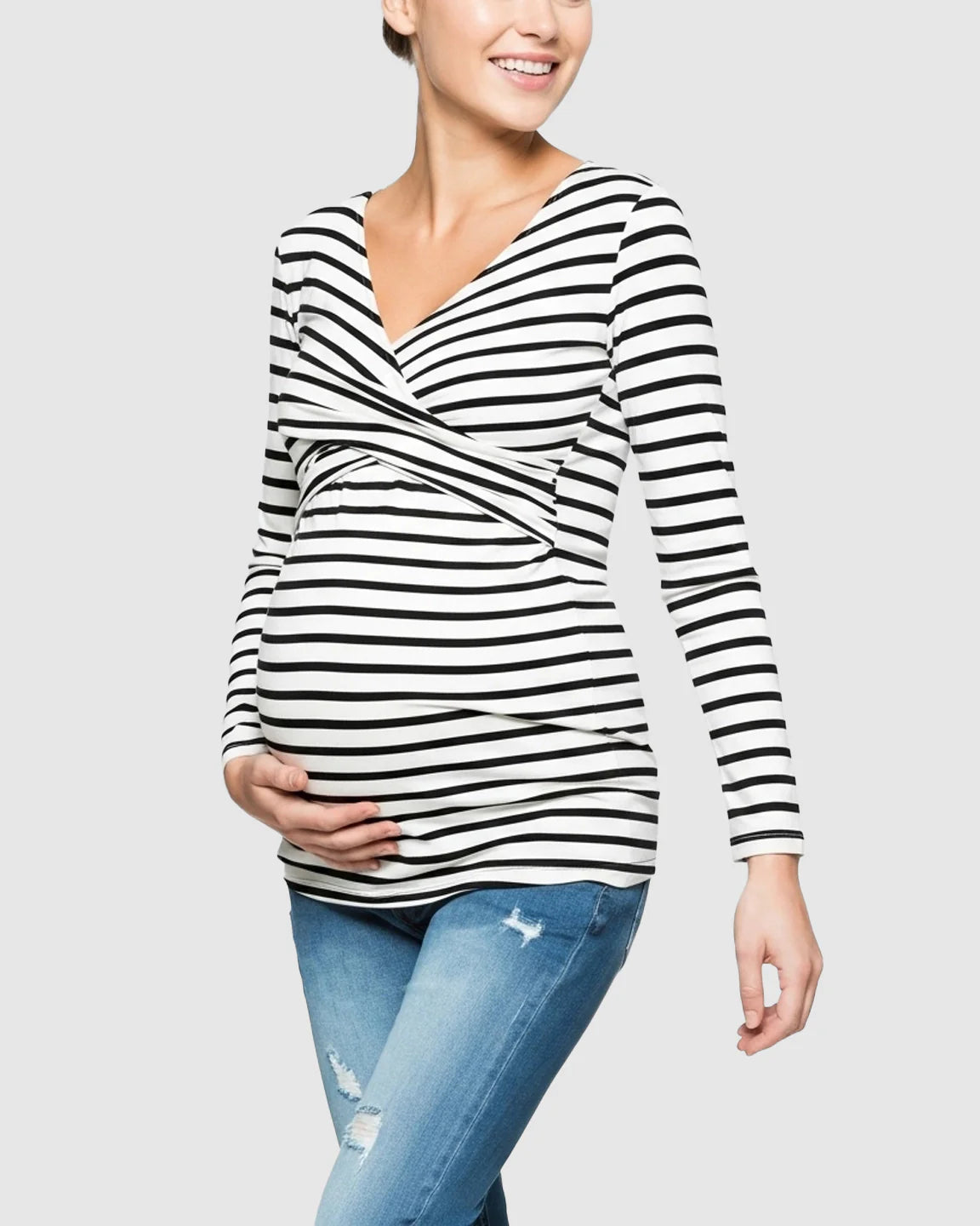 Smiling pregnant woman in black and white striped long-sleeve V-neck maternity and nursing top.