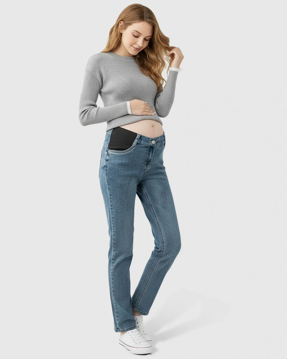 Pregnant woman in light wash straight-leg maternity jeans with black side panels and a grey ribbed sweater.