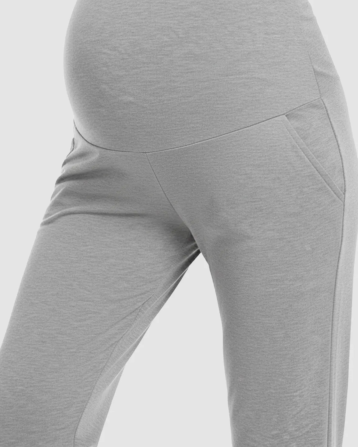 Light gray maternity pants with a wide elastic waistband, side pockets, and a relaxed fit.
