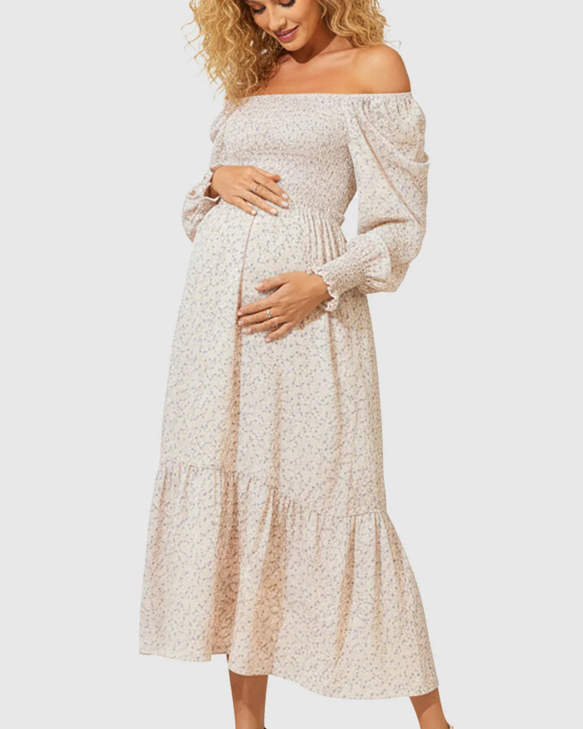 Off-shoulder flowy floral maternity midi dress with smocked bodice and tiered skirt.