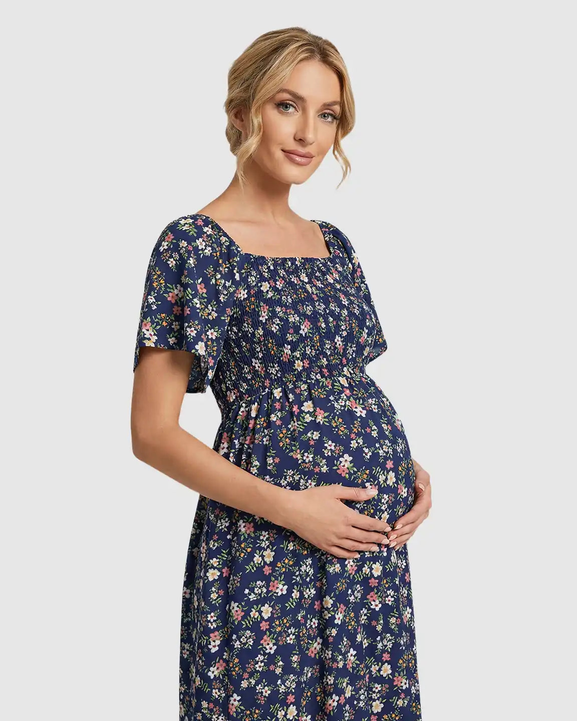 Navy floral flutter-sleeve smocked maternity midi dress with tiered skirt.