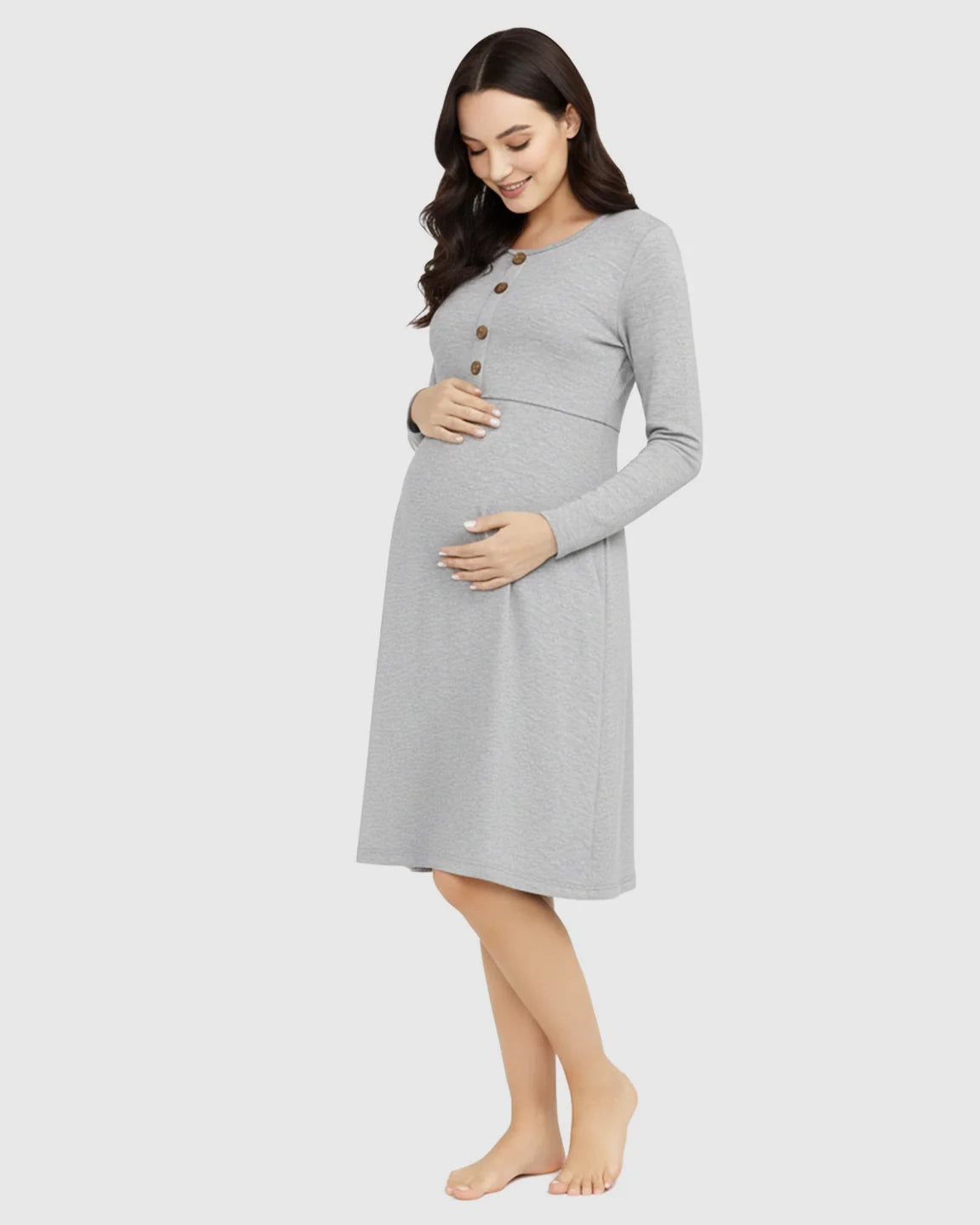 Pregnant woman in a gray long-sleeve empire waist nursing dress with brown buttons.