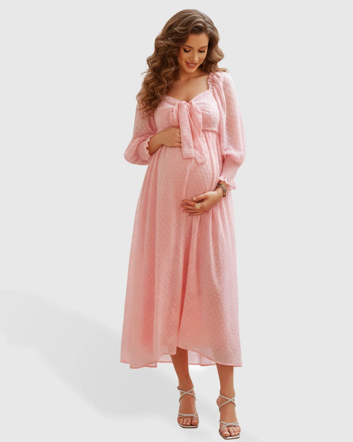 Pregnant woman in a pink polka-dot maternity maxi dress with a square neckline and long sleeves.