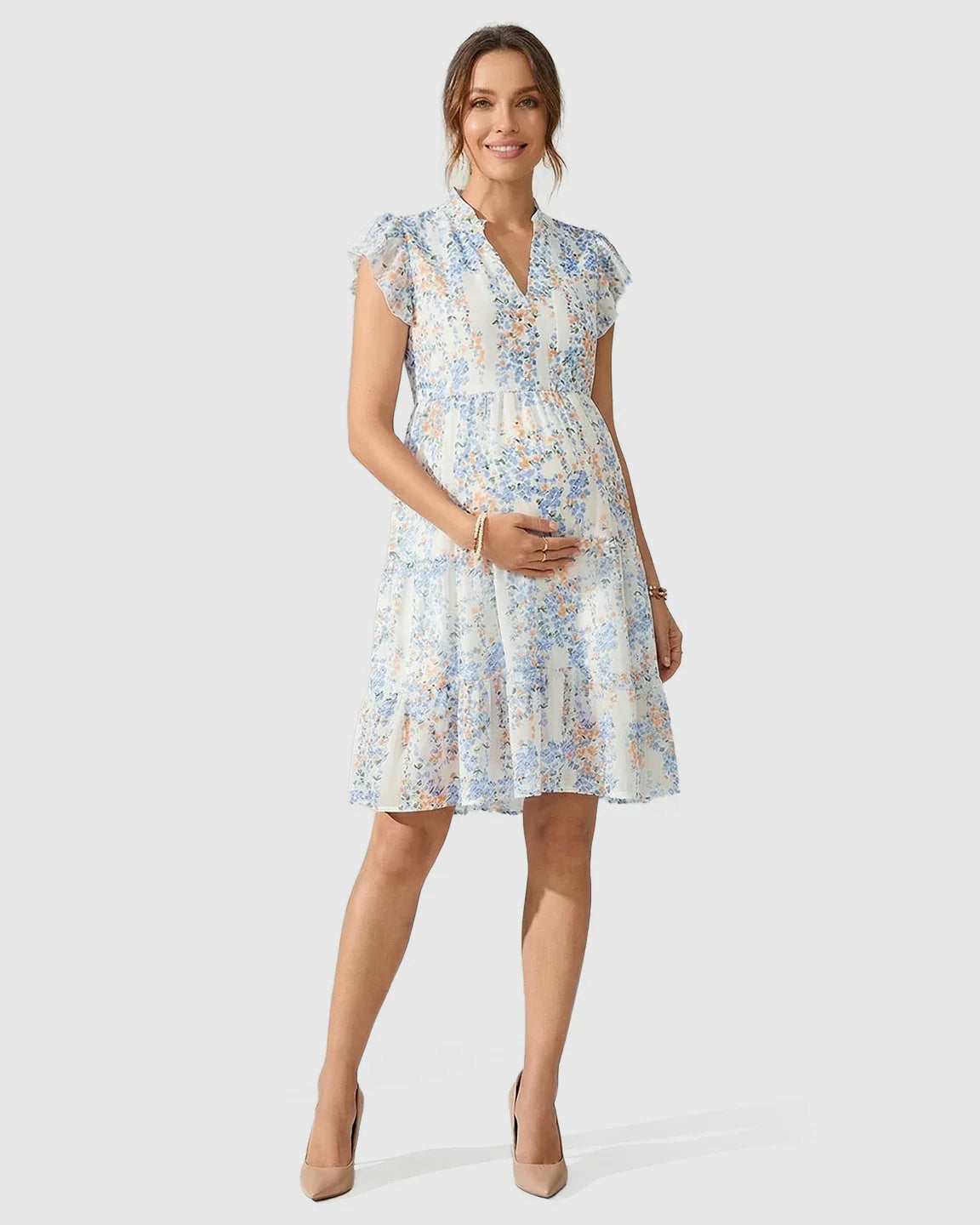 White A-line maternity dress with blue and orange floral print, flutter sleeves, and tiered flowy skirt.