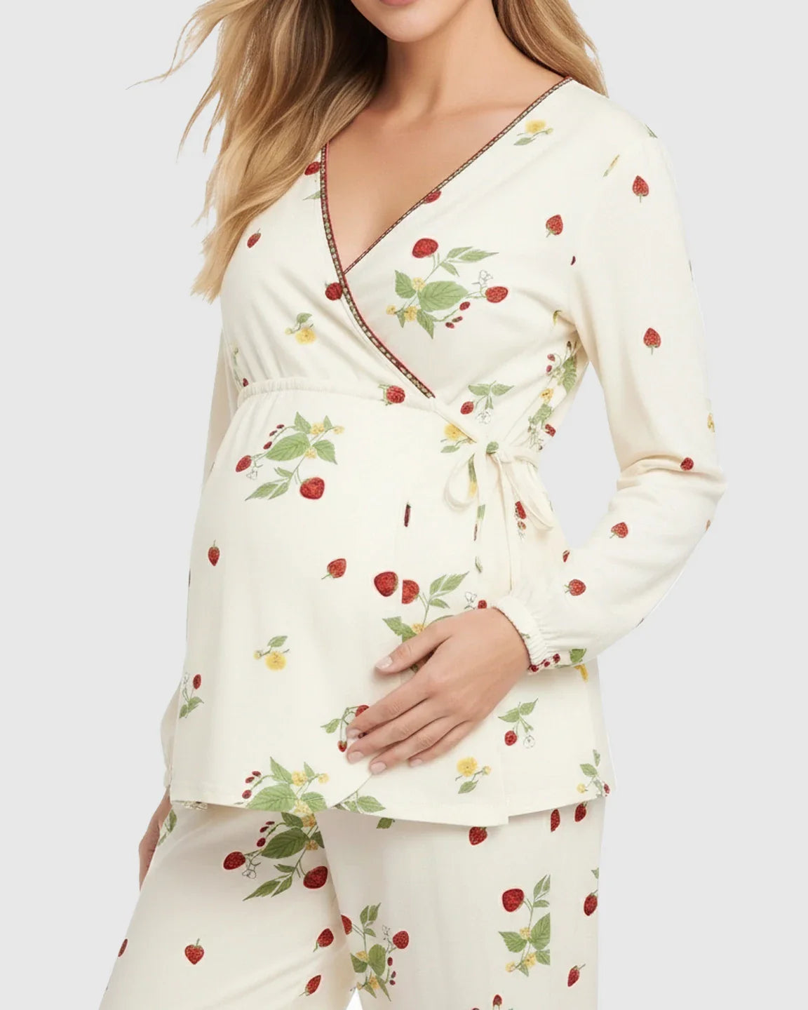 Pregnant woman in cream floral strawberry print kimono-style maternity pajama set with wrap top and pants.