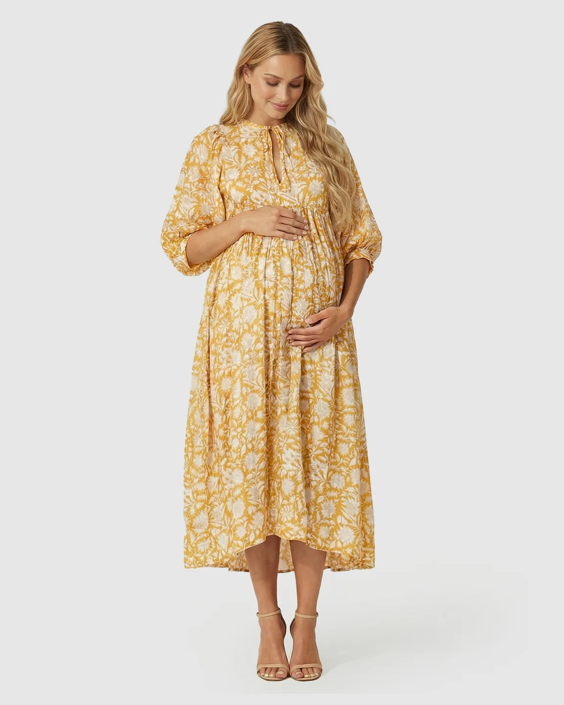 Maternity midi dress in yellow floral print with gathered shoulders, puff sleeves, and knot detail.