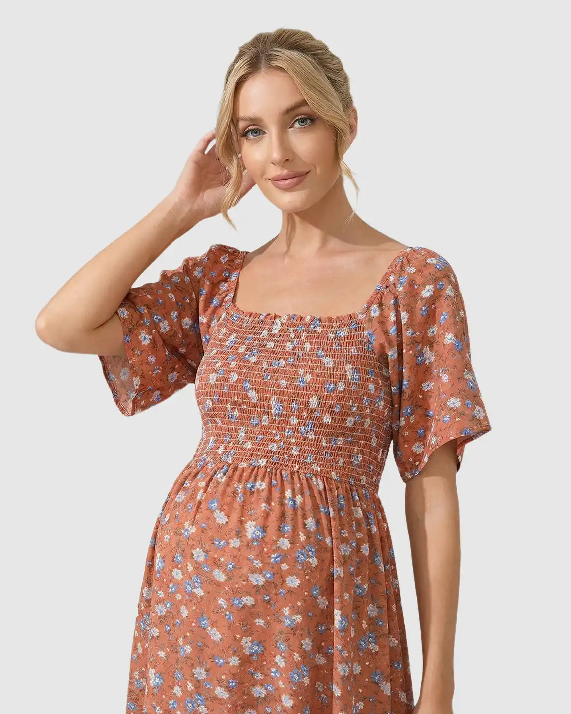 Maternity midi dress in rust with blue and white floral print, smocked bodice, square neckline, and flutter sleeves.