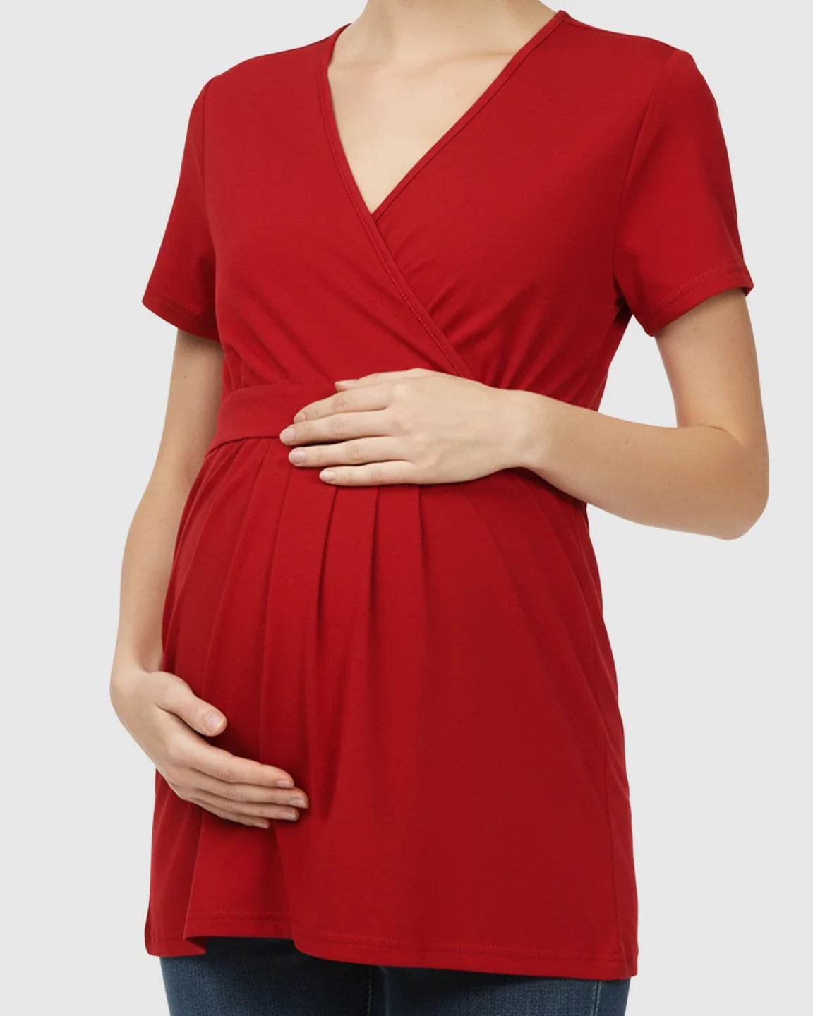 Red V-neck wrap-style maternity top with short sleeves, adjustable waist tie, and pleats, worn by a pregnant woman.