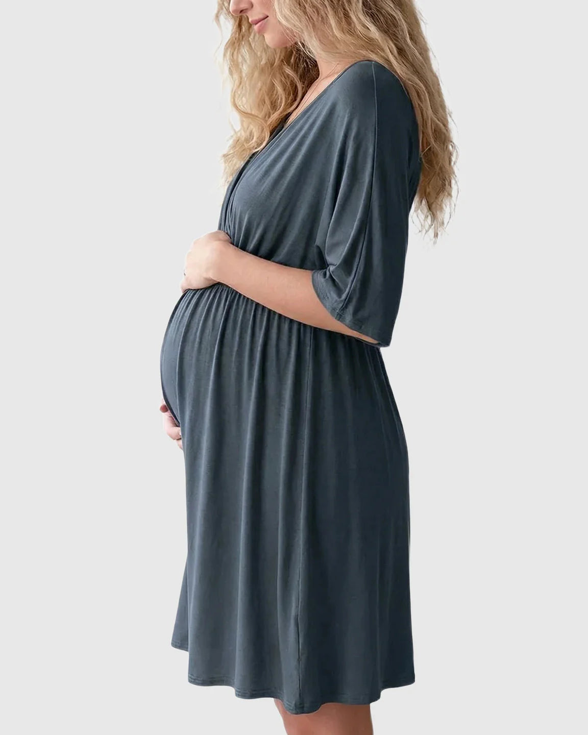 Pregnant woman in a dark gray cross-front maternity midi dress with 3/4 sleeves, flattering her bump.