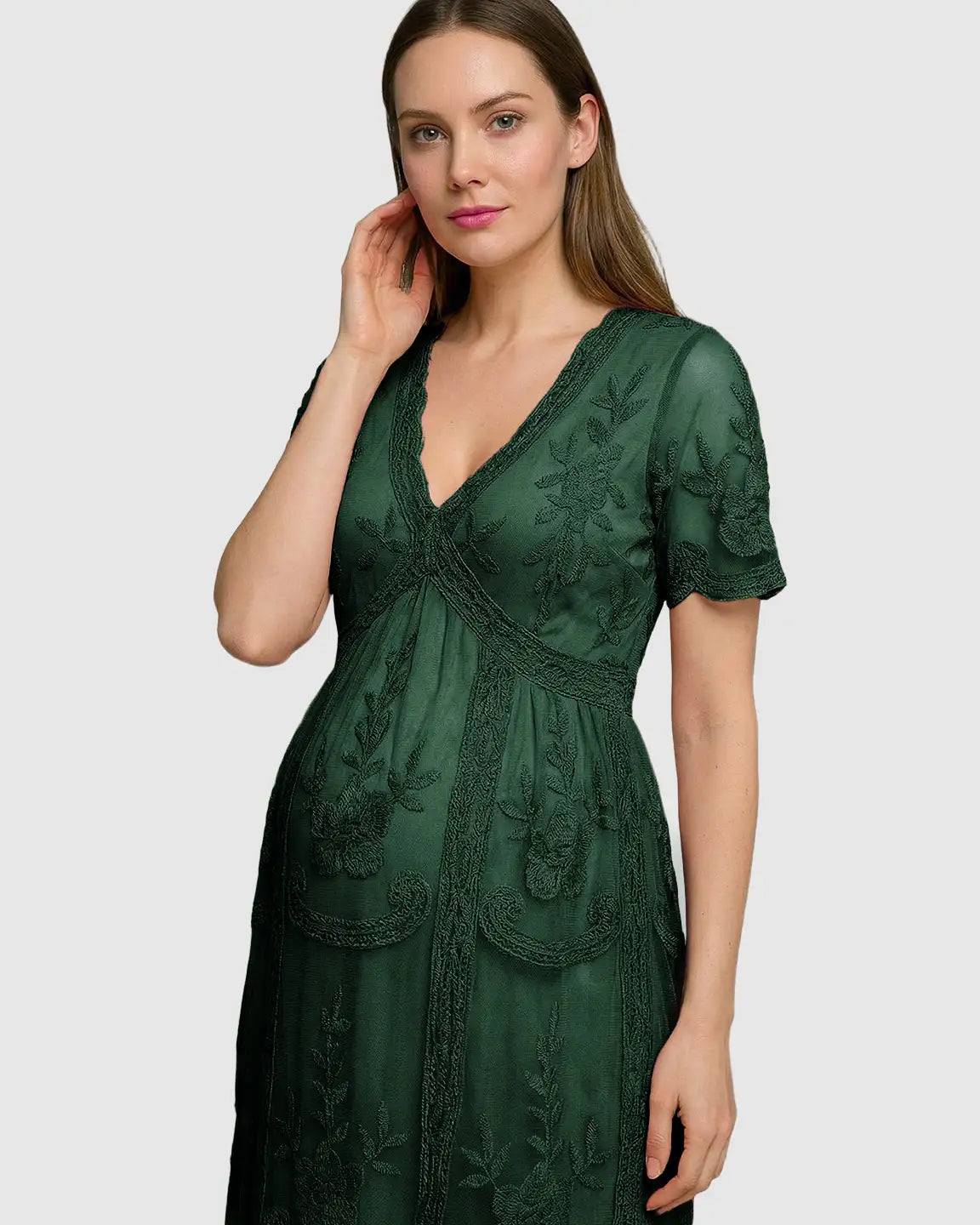 Maternity midi dress in dark green lace with V-neck, three-quarter sleeves, and swing skirt, modeled by a pregnant woman.