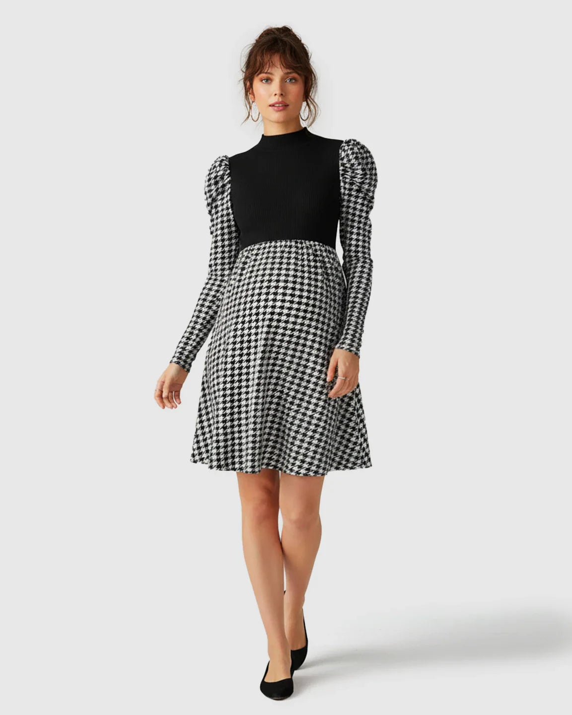 Elegant maternity short dress with black knit bodice, houndstooth skirt, and puff sleeves.