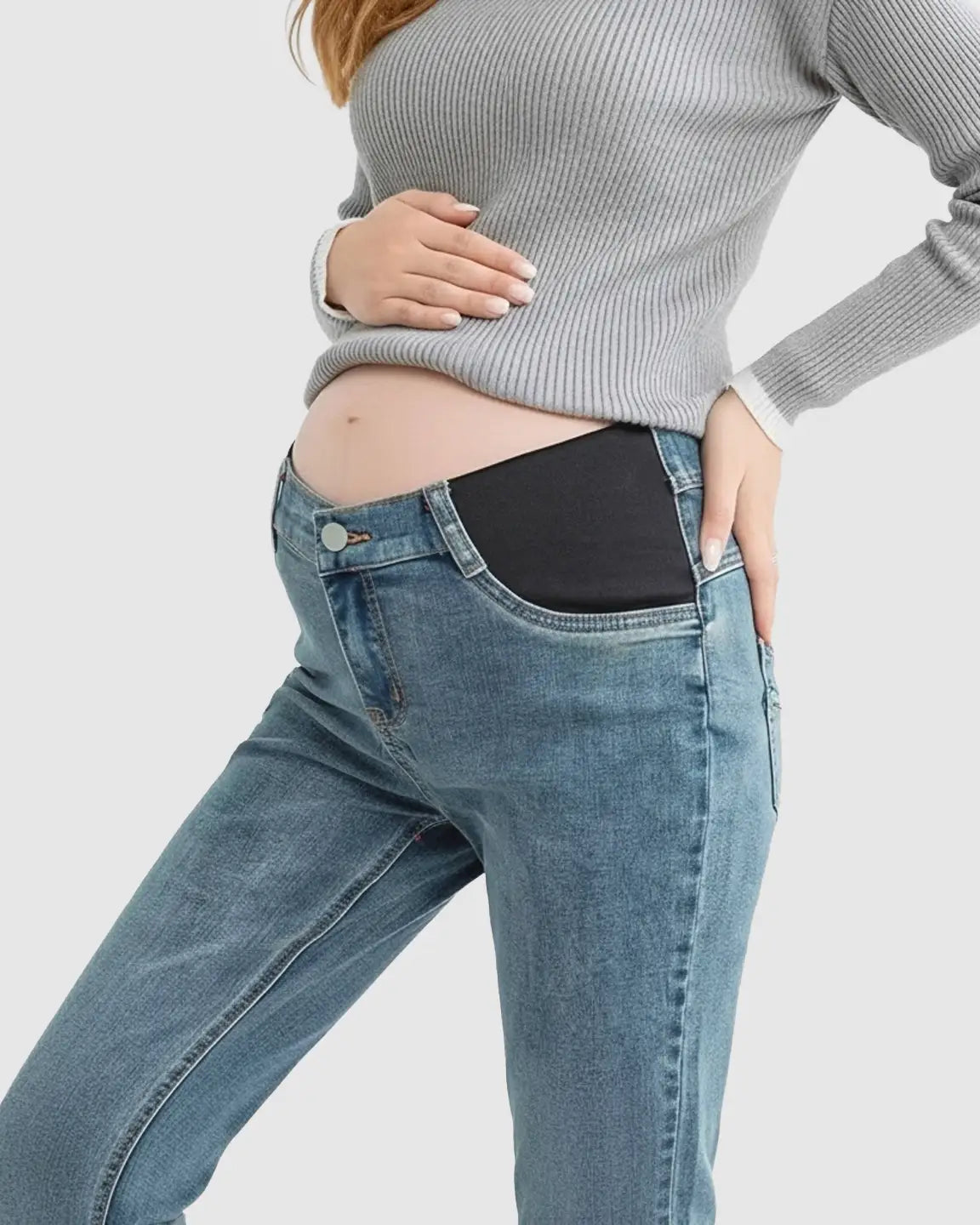 Maternity jeans with side panel support, light wash denim, and a straight-leg cut, worn by a pregnant woman.