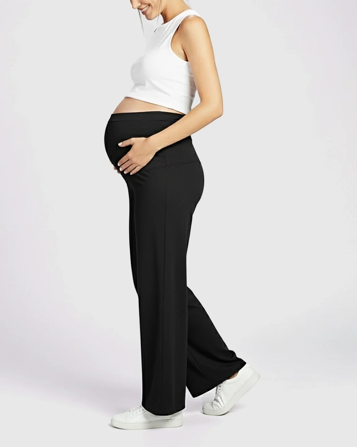 Pregnant woman in black Comfort Fit elastic waist maternity pants with a full-length, loose fit.