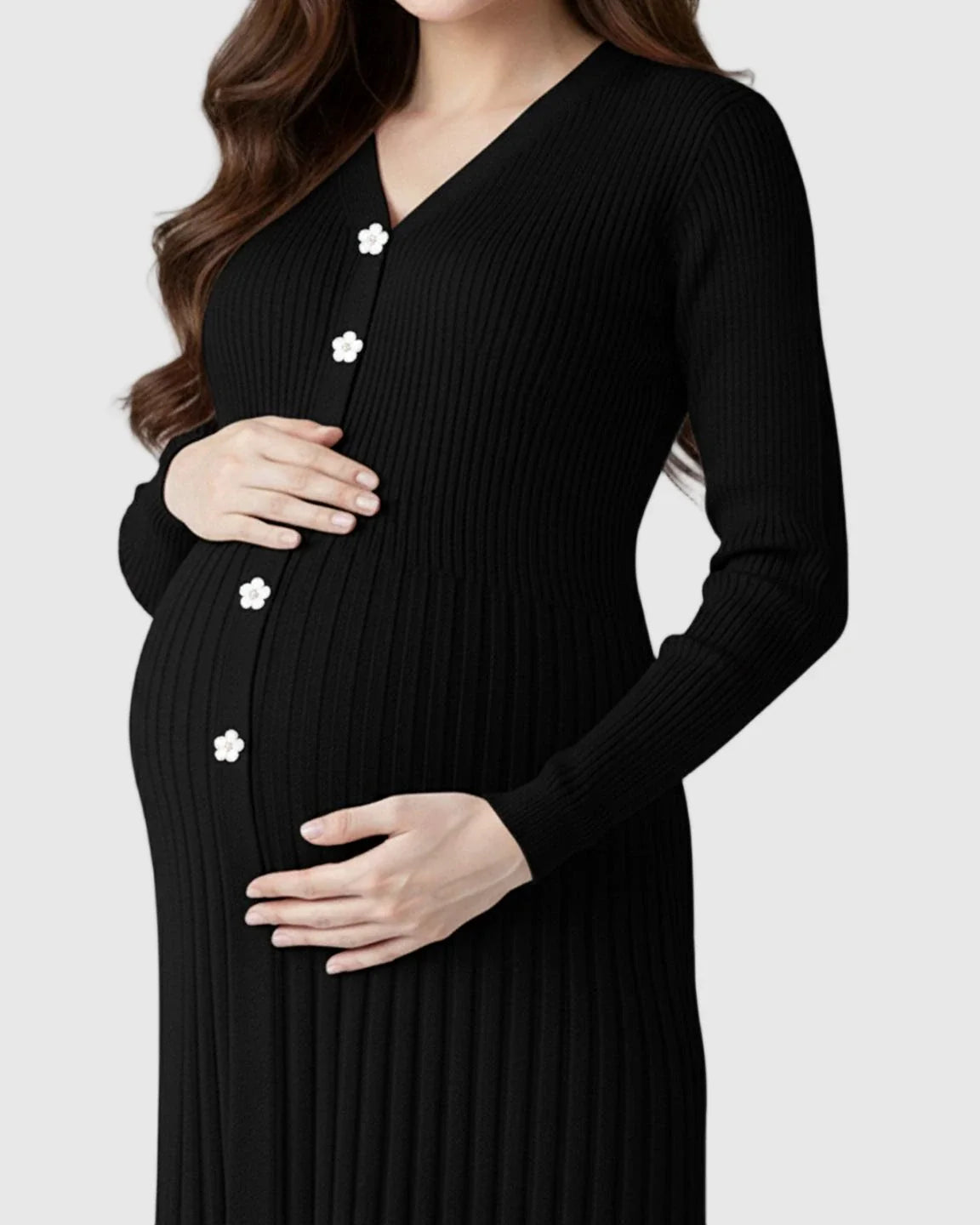 Pregnant woman in a black ribbed knit maternity midi dress with white floral buttons and V-neck.