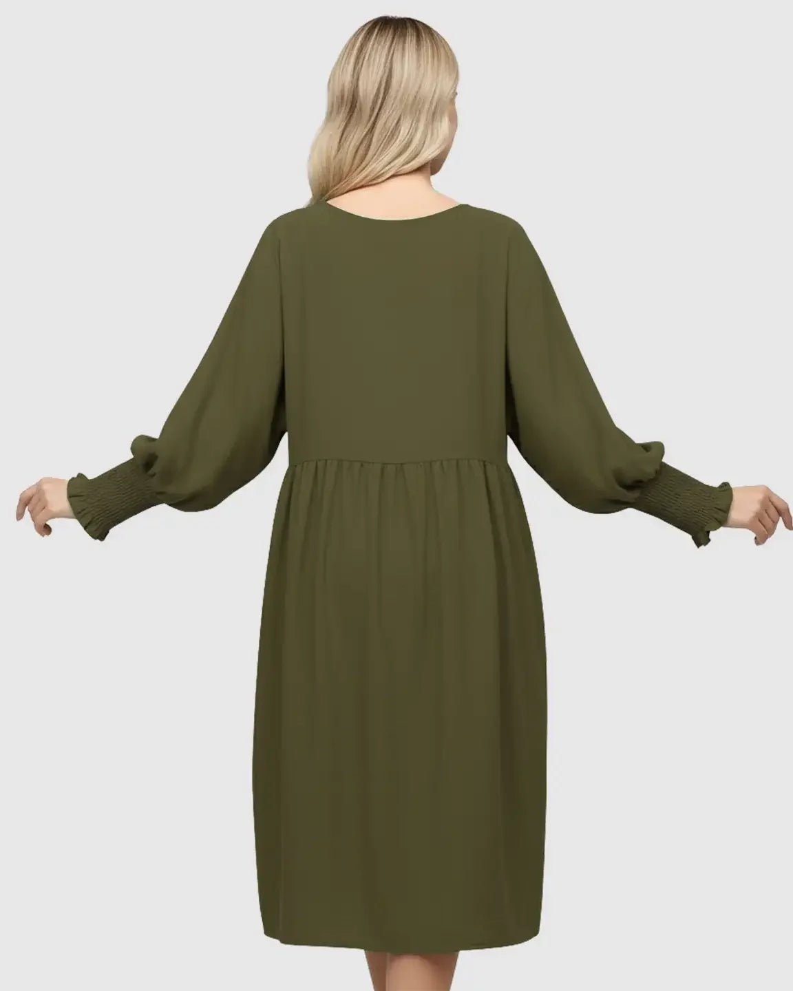 Back view of a pregnant woman in a flowy olive green smocked sleeve casual dress.