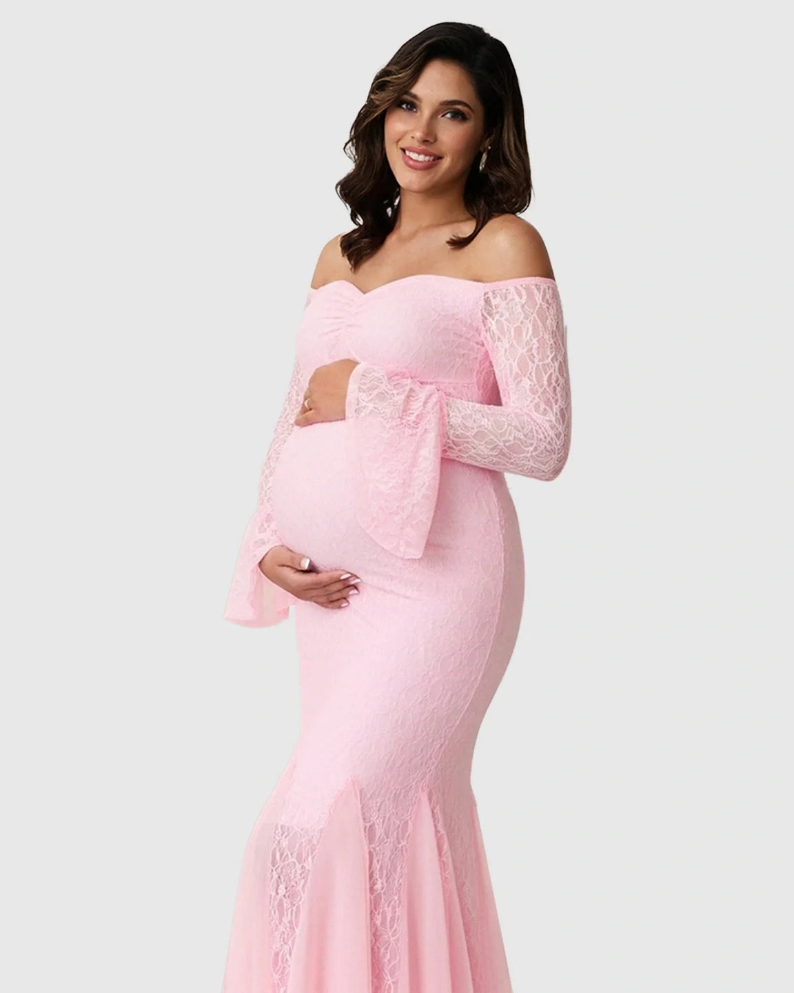 Smiling pregnant woman in a pink lace off-shoulder mermaid maternity maxi dress with bell sleeves.