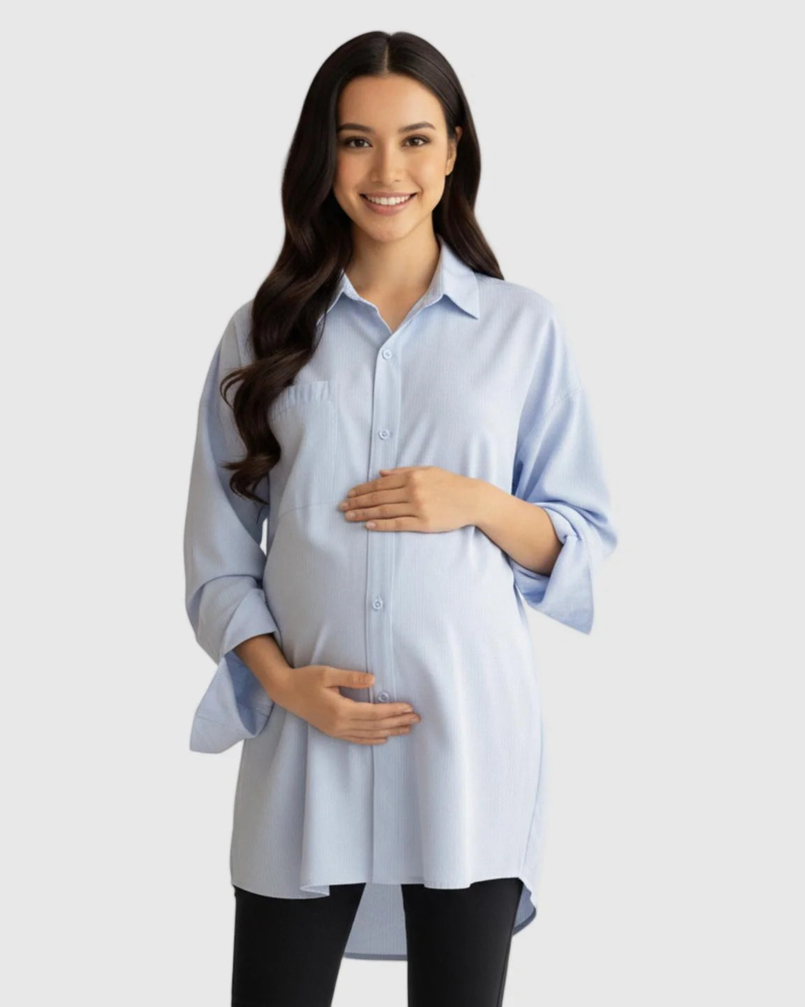 Smiling pregnant woman in a light blue cotton lapel-collar button-front maternity tunic.