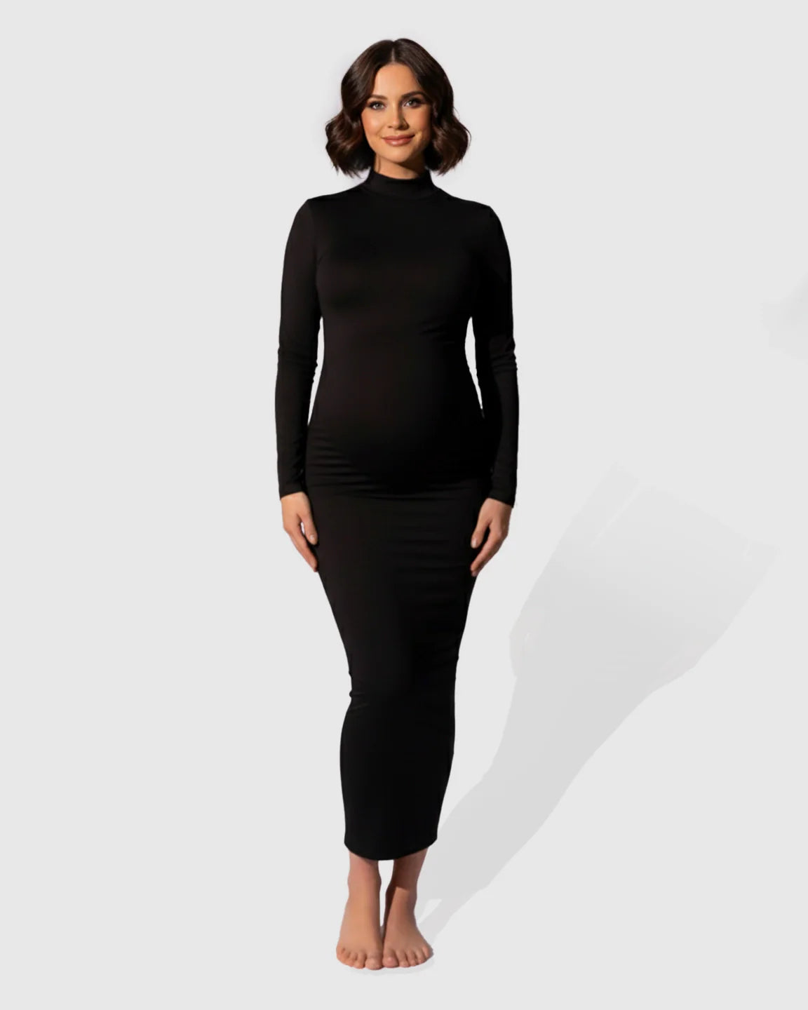 Black mock-neck bodycon maternity maxi dress with long sleeves, worn by a smiling pregnant woman.