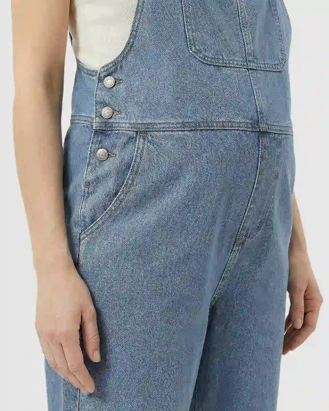 Light blue loose denim maternity jumpsuit with adjustable straps and side buttons.