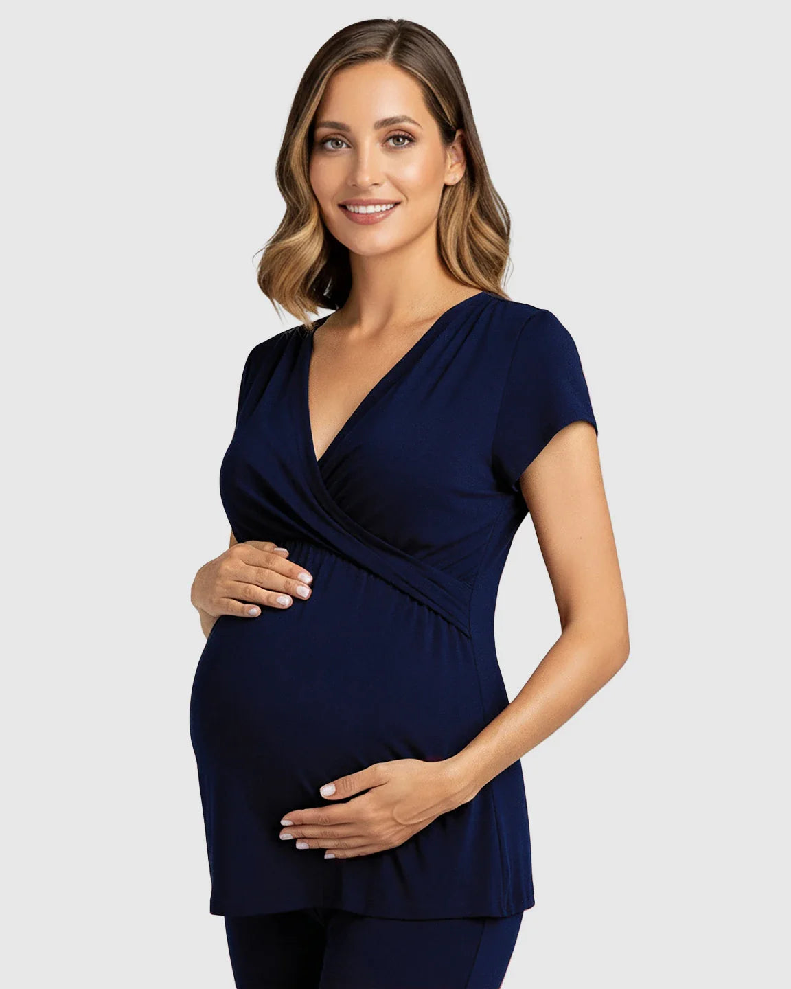 Smiling pregnant woman in a navy blue wrap V-neck short-sleeve maternity and nursing top.